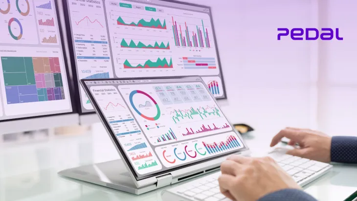 Person analyzing driving school automation and training analytics on laptop and monitor dashboards with Pedal Mobility software interface