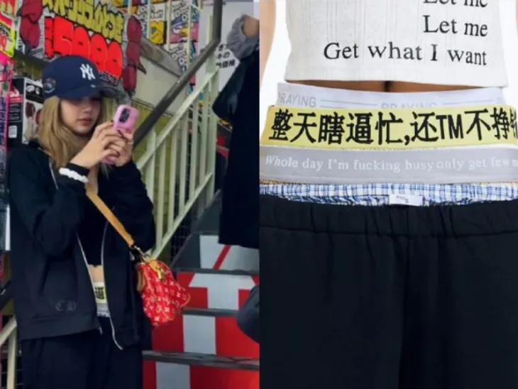 BLACKPINK’s Lisa spotted in Japan wearing casual streetwear, including black hoodie, cap, and pants with bold Chinese characters and English phrase ‘Whole day I’m f*cking busy,’ sparking trending discussions on Weibo