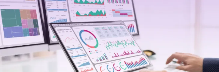 Person analyzing driving school automation and training analytics on laptop and monitor dashboards with Pedal Mobility software interface